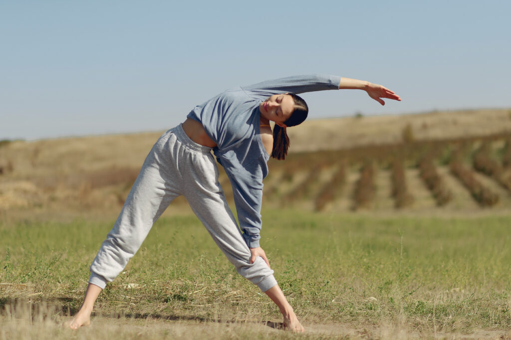 Cute girl training on a sky backgroung in a field